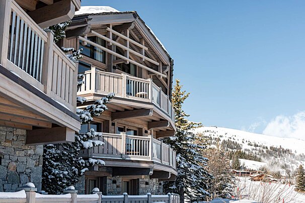 A large wooden building with a balcony in the snow