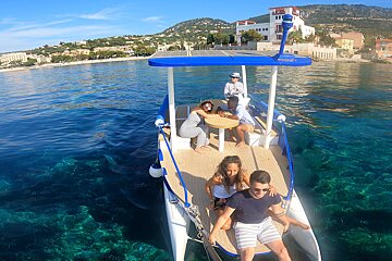 A group of people are sitting on a boat in the ocean