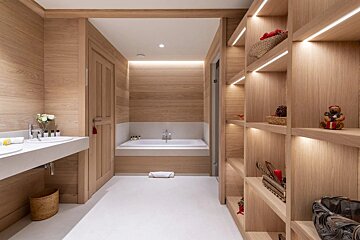 A bathroom with wooden shelves and a bathtub