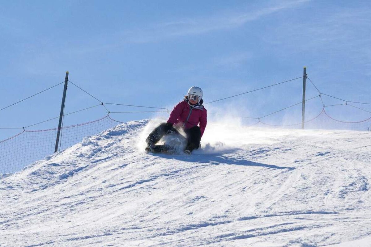 a woman on a sledge on a piste