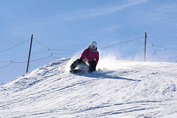 a woman on a sledge on a piste