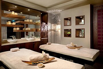 Two massage tables in a spa with candles on them