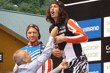 a man zipping up a vest on another man
