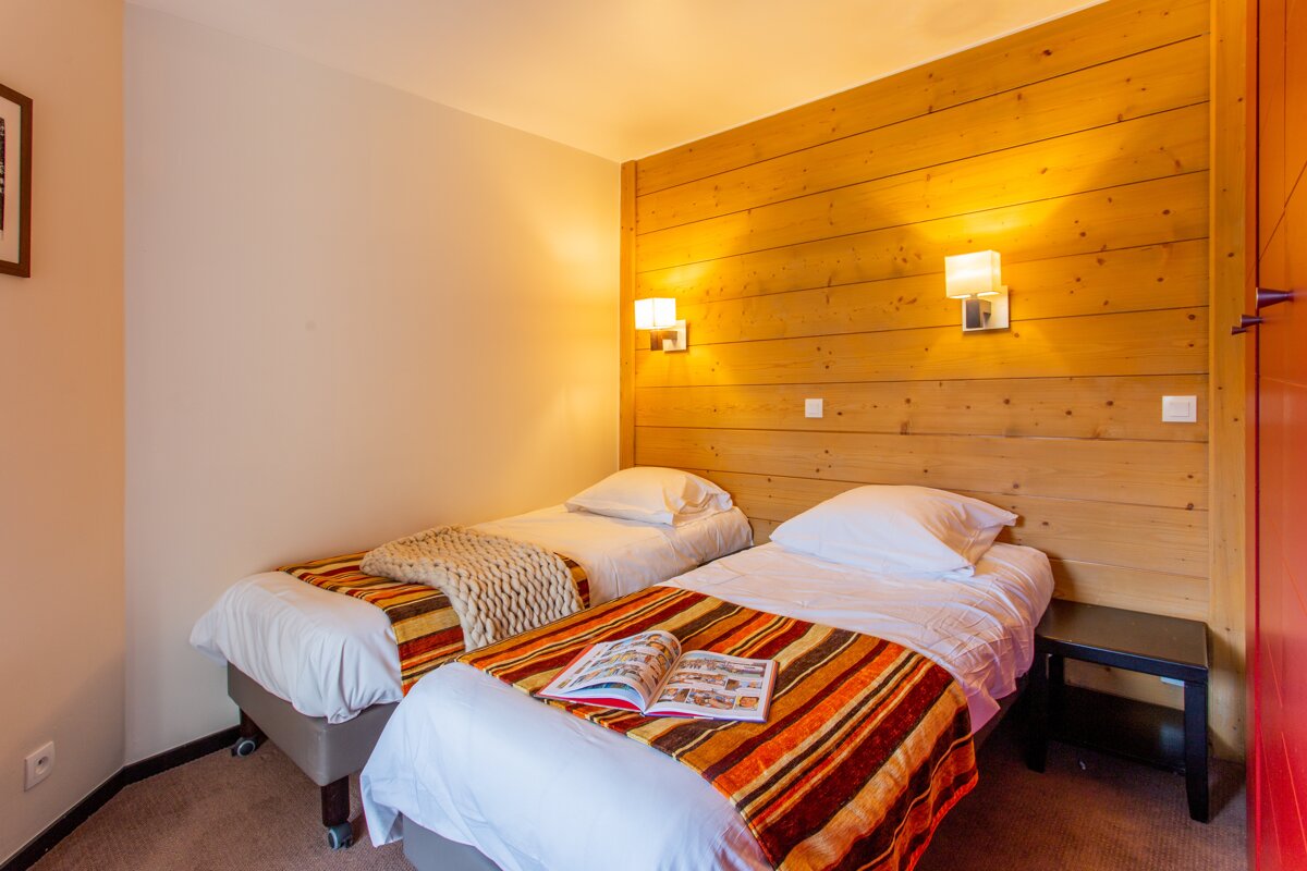 A bedroom with two beds and a book on the bed