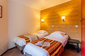 A bedroom with two beds and a book on the bed
