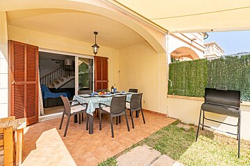 A patio with a table and chairs and a grill
