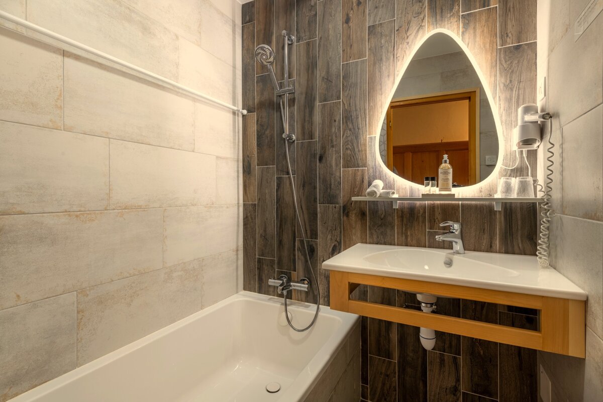 A bathroom with a bathtub sink and mirror