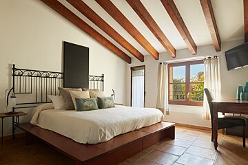 A bedroom with a large bed and a window