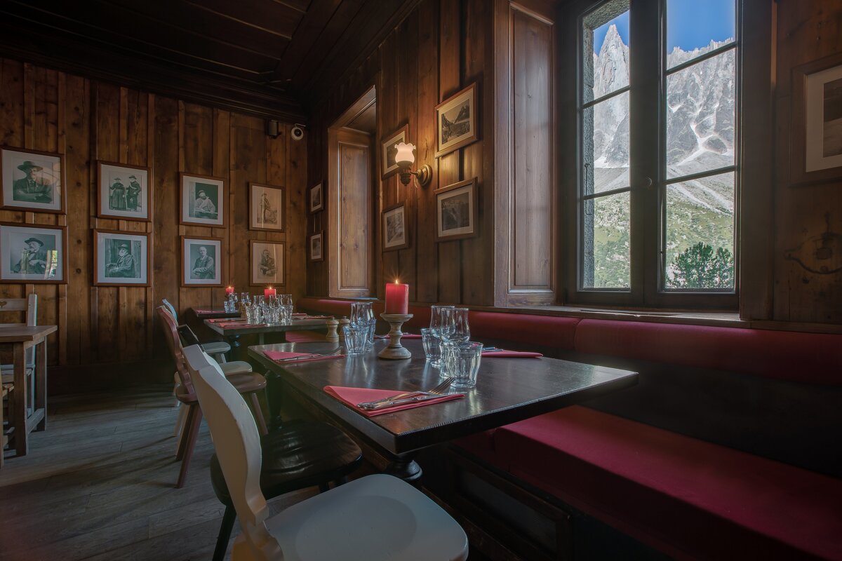 A dining room with tables and chairs and pictures on the wall