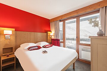 A hotel room with a bed and a book on it