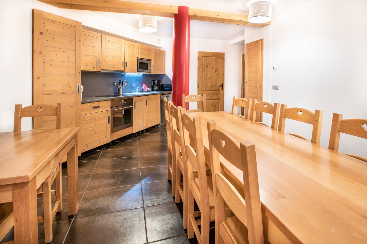 A kitchen with a long wooden table and chairs