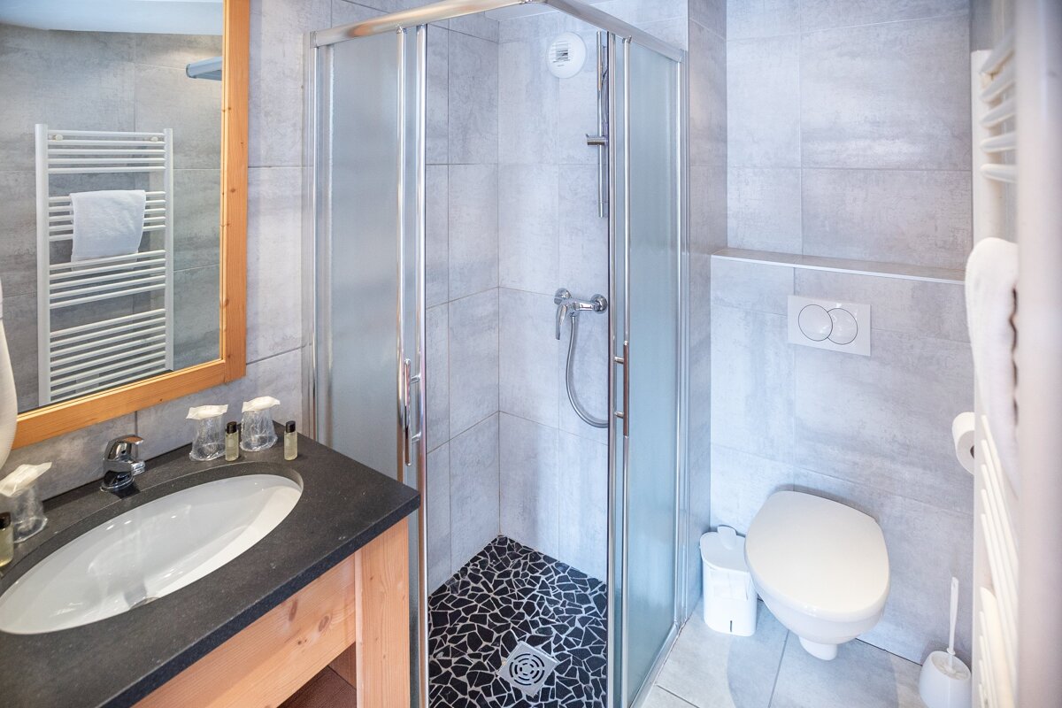 A bathroom with a toilet a sink and a shower