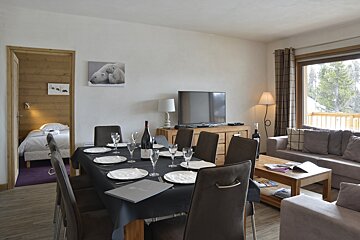 A living room with a dining table and chairs