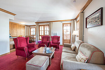 A living room with red chairs and a couch