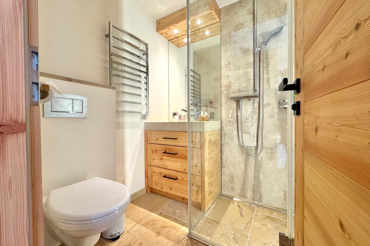 A bathroom with a toilet and a walk in shower