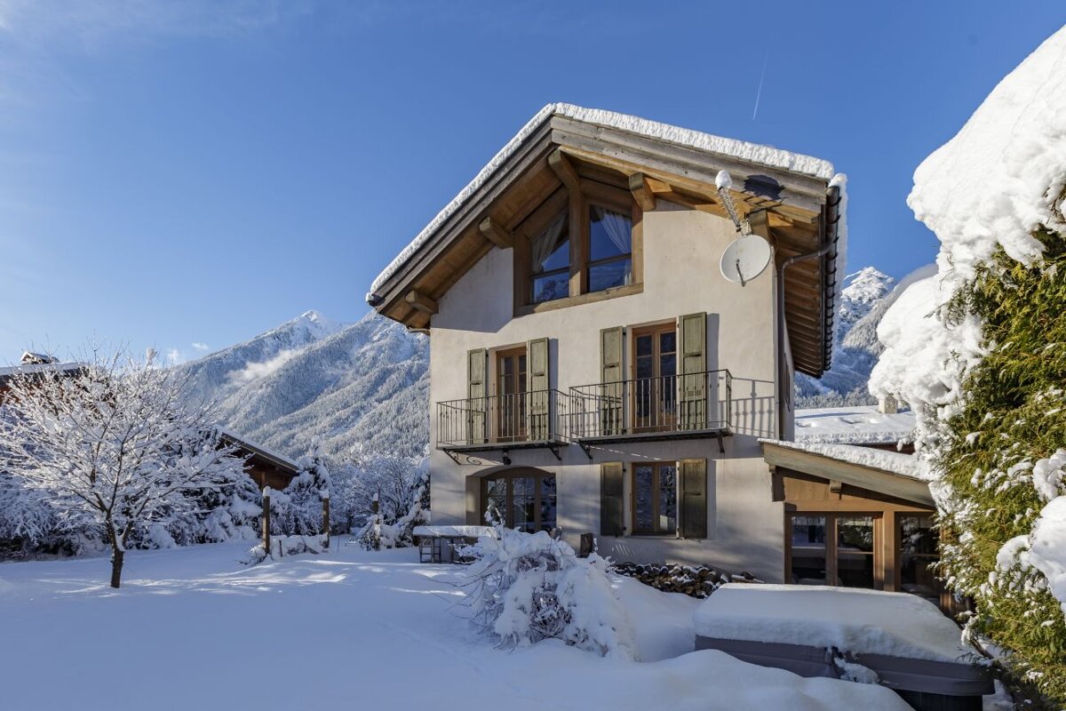 A snowy house with a satellite dish on the roof