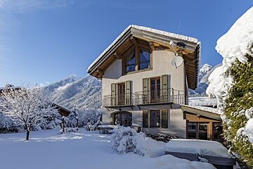 A snowy house with a satellite dish on the roof