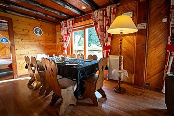 A wooden dining room with a table and chairs and a lamp