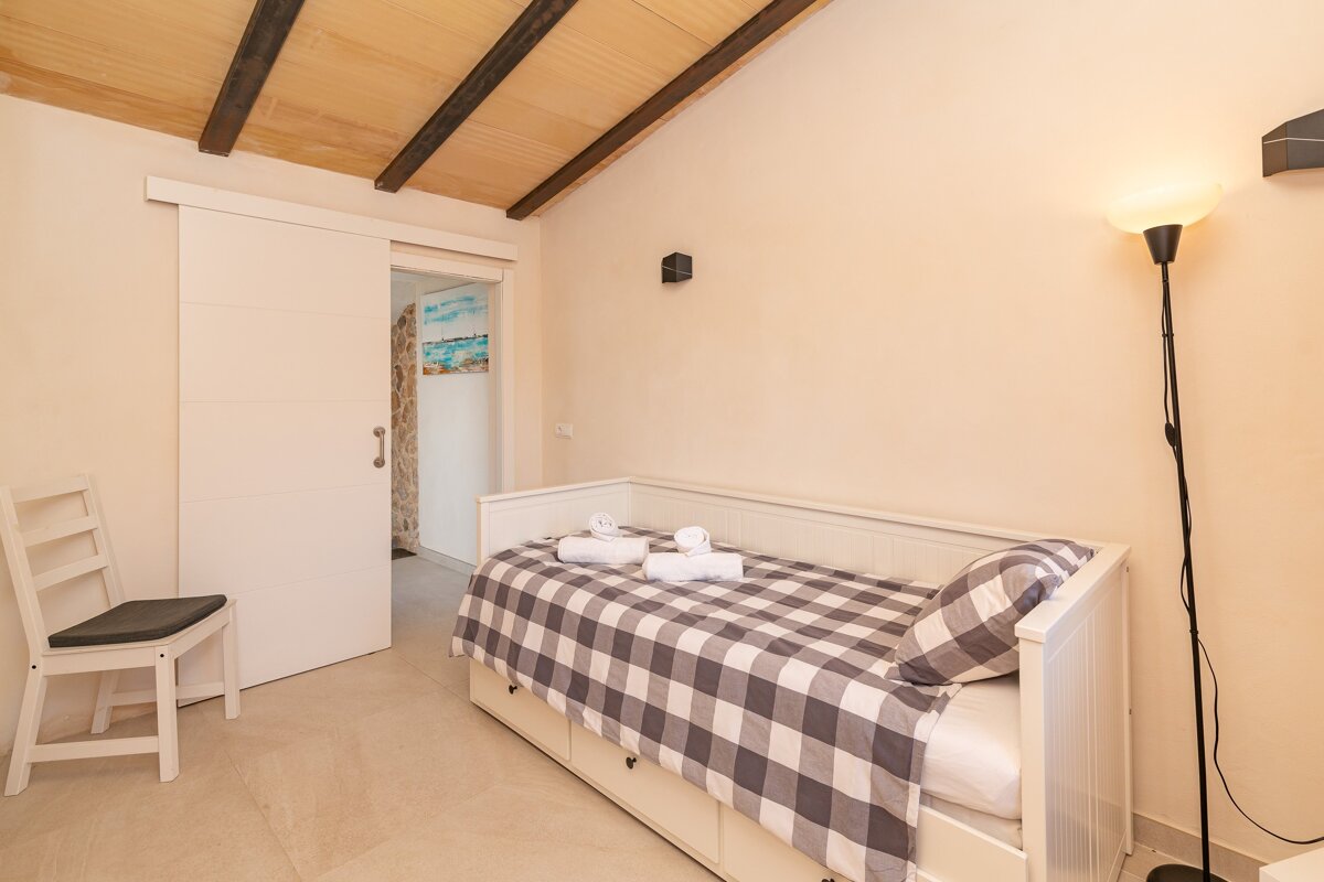 A bedroom with a sliding door that leads to a bathroom
