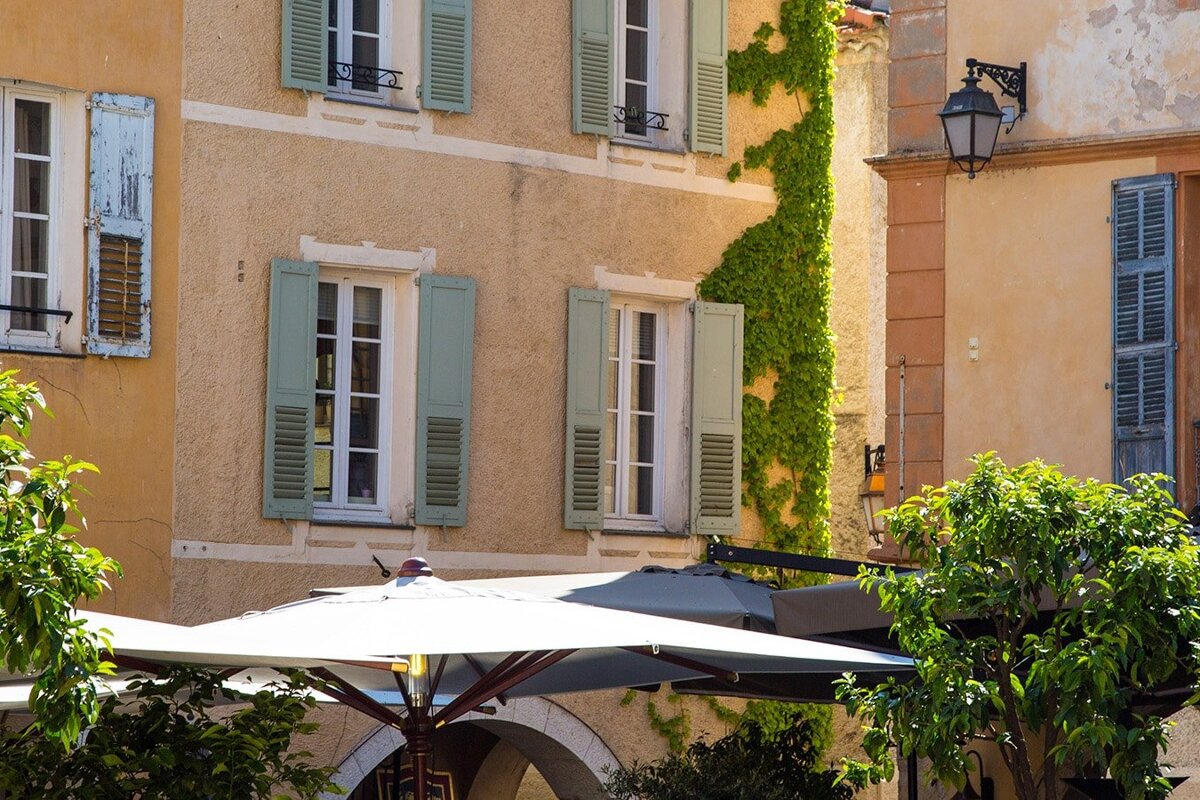 A building with shutters on the windows and a sign that says ' a ' on it
