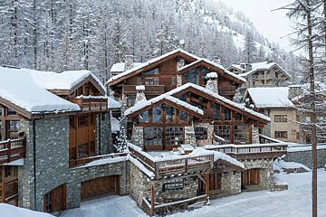 A large house with a lot of windows is covered in snow
