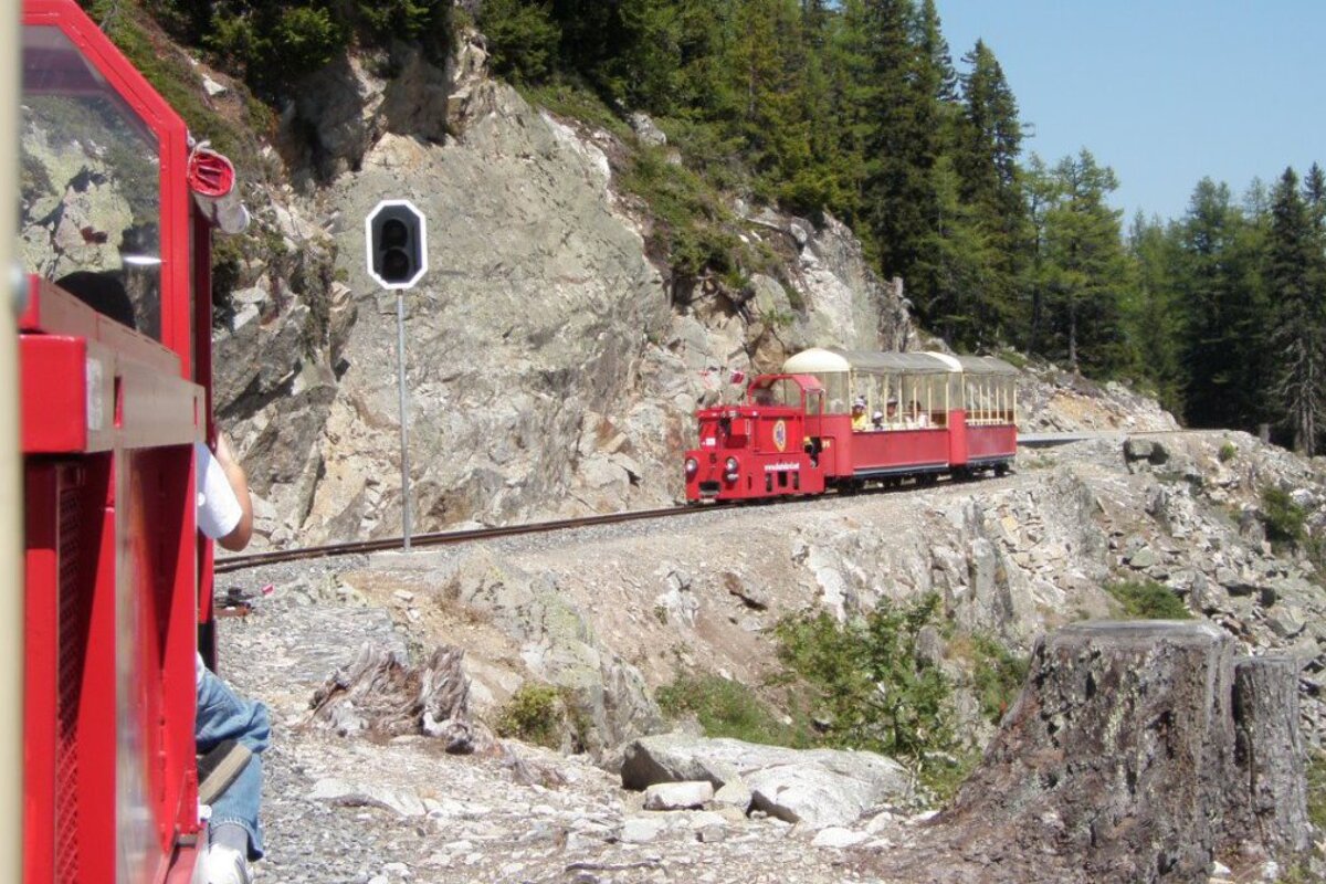 a small red train on a muontain side