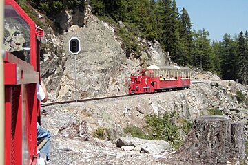 a small red train on a muontain side