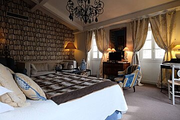 A bedroom with a large bed and a couch