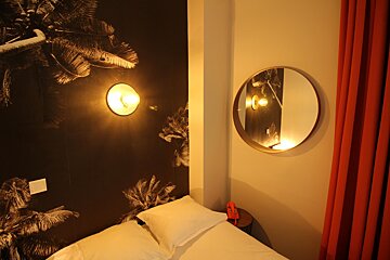 A bedroom with a bed and a mirror on the wall
