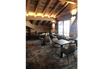 Tables and chairs in a room with a wooden ceiling