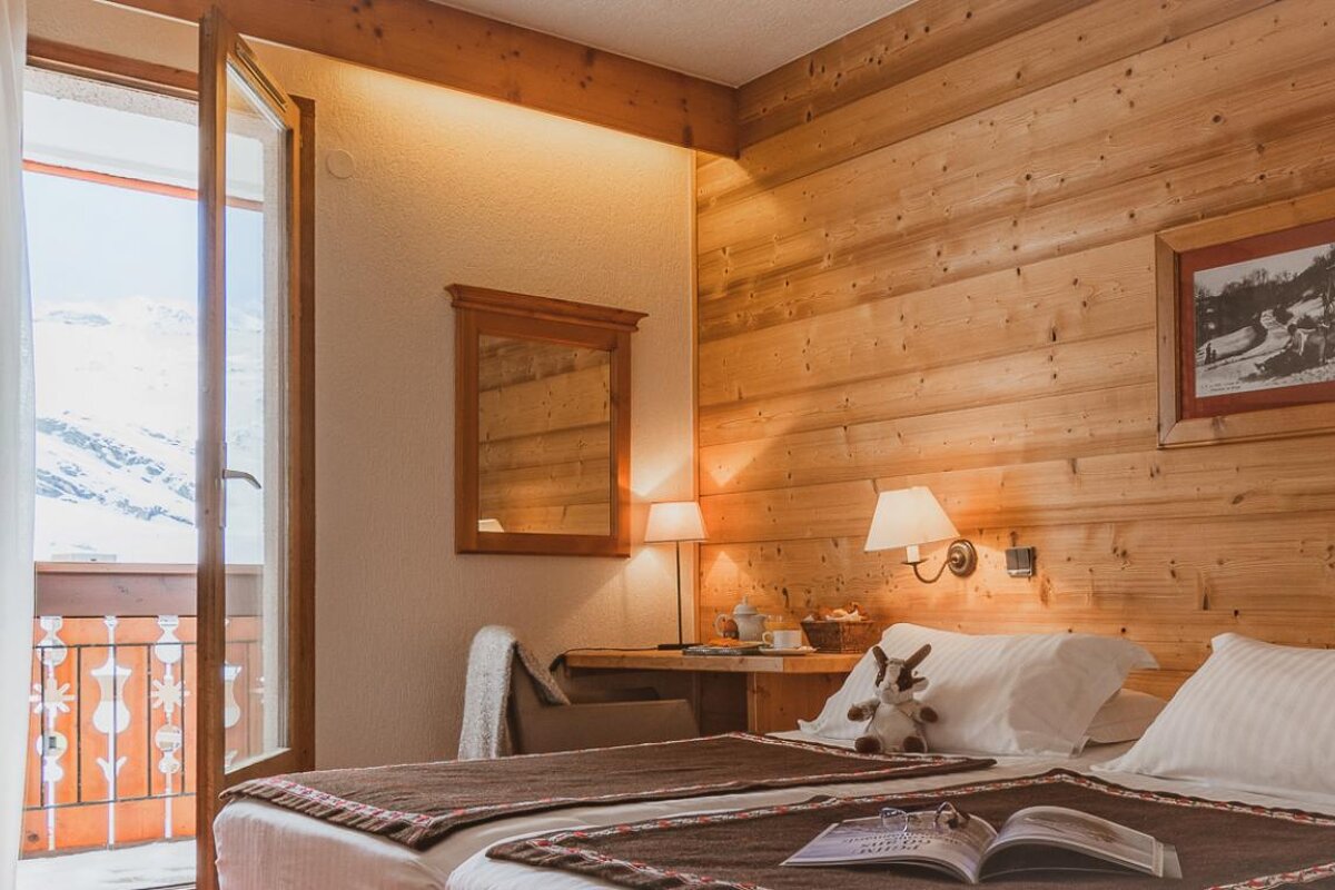 A hotel room with a bed and a book on it