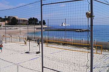 caged volleyball court on Plage du Larvotto Beach