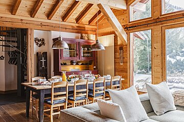 A wooden house with a dining table and chairs