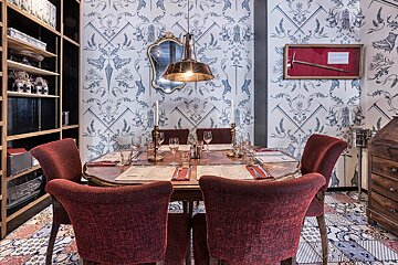 A dining room with red chairs and a table