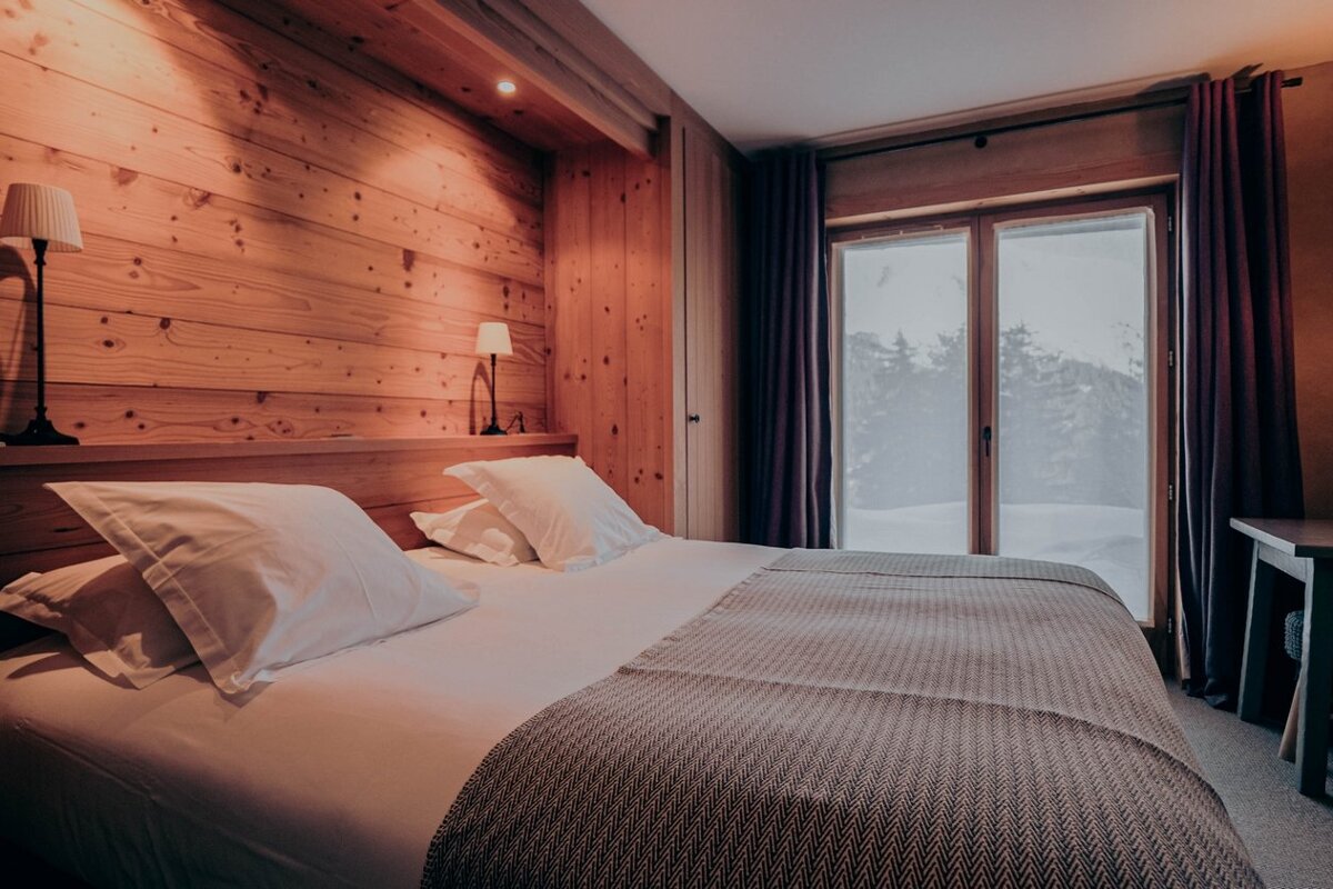 A bedroom with a large bed and a large window