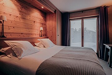 A bedroom with a large bed and a large window