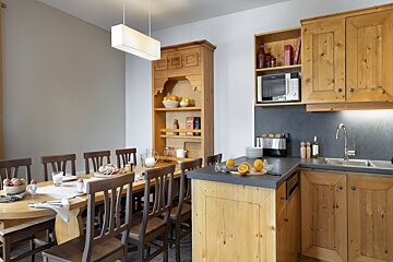 A kitchen with a table and chairs and a microwave