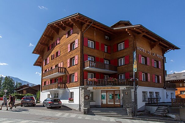 The hotel de la poste has red shutters on the windows