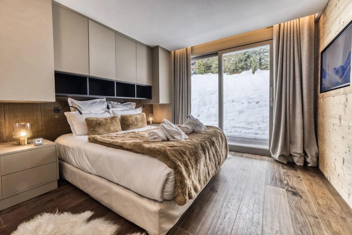 A bedroom with a large bed and a sliding glass door