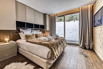 A bedroom with a large bed and a sliding glass door