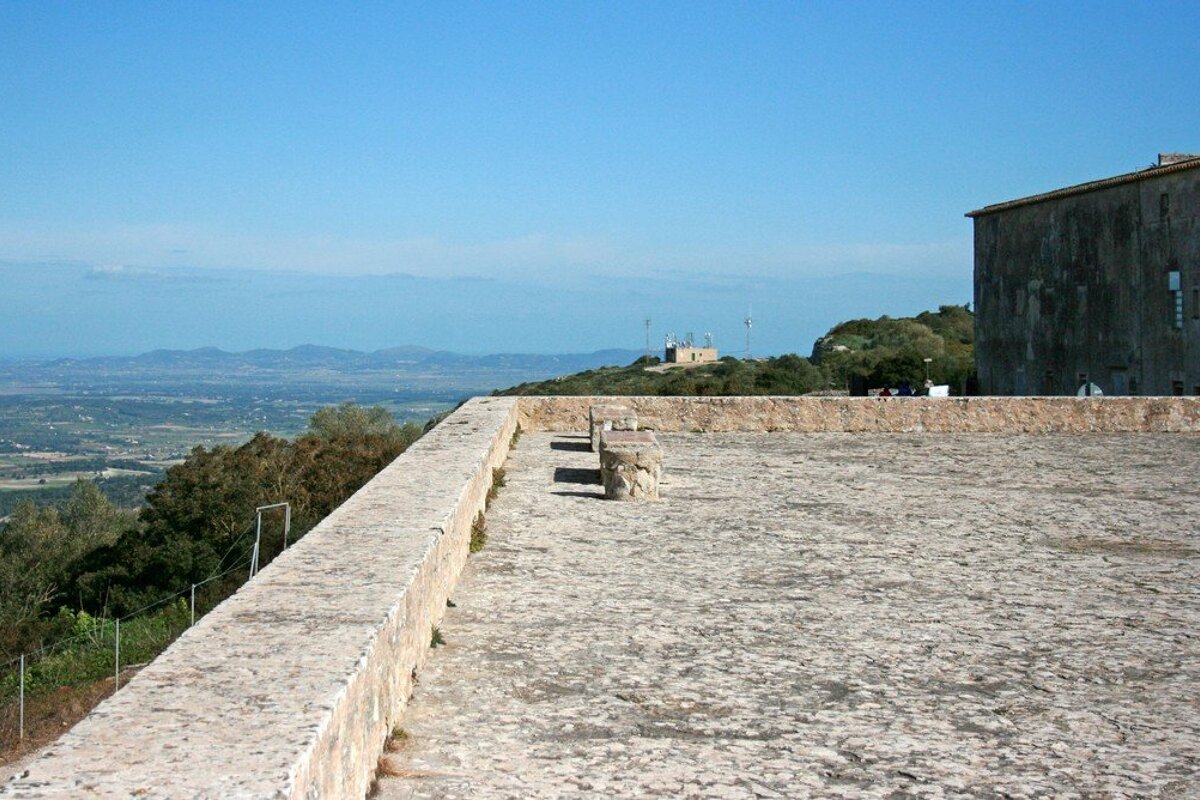 A stone wall with a view of the mountains in the background