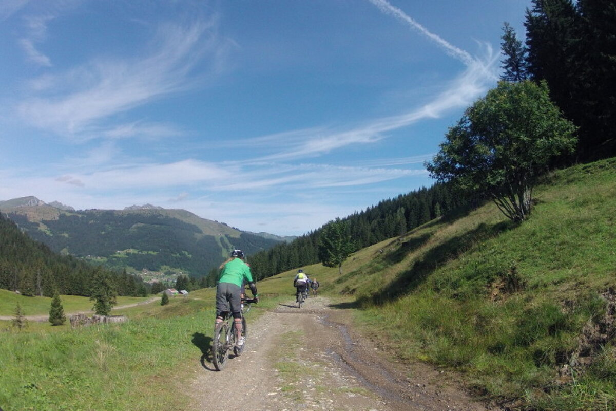a group of mountain bikers on a trail in morzine