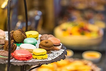 A tray of colorful macarons sits on a table