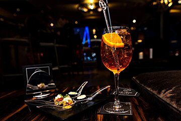 A glass of orange juice with a spoon in it