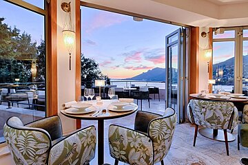 A restaurant with a view of the ocean and mountains