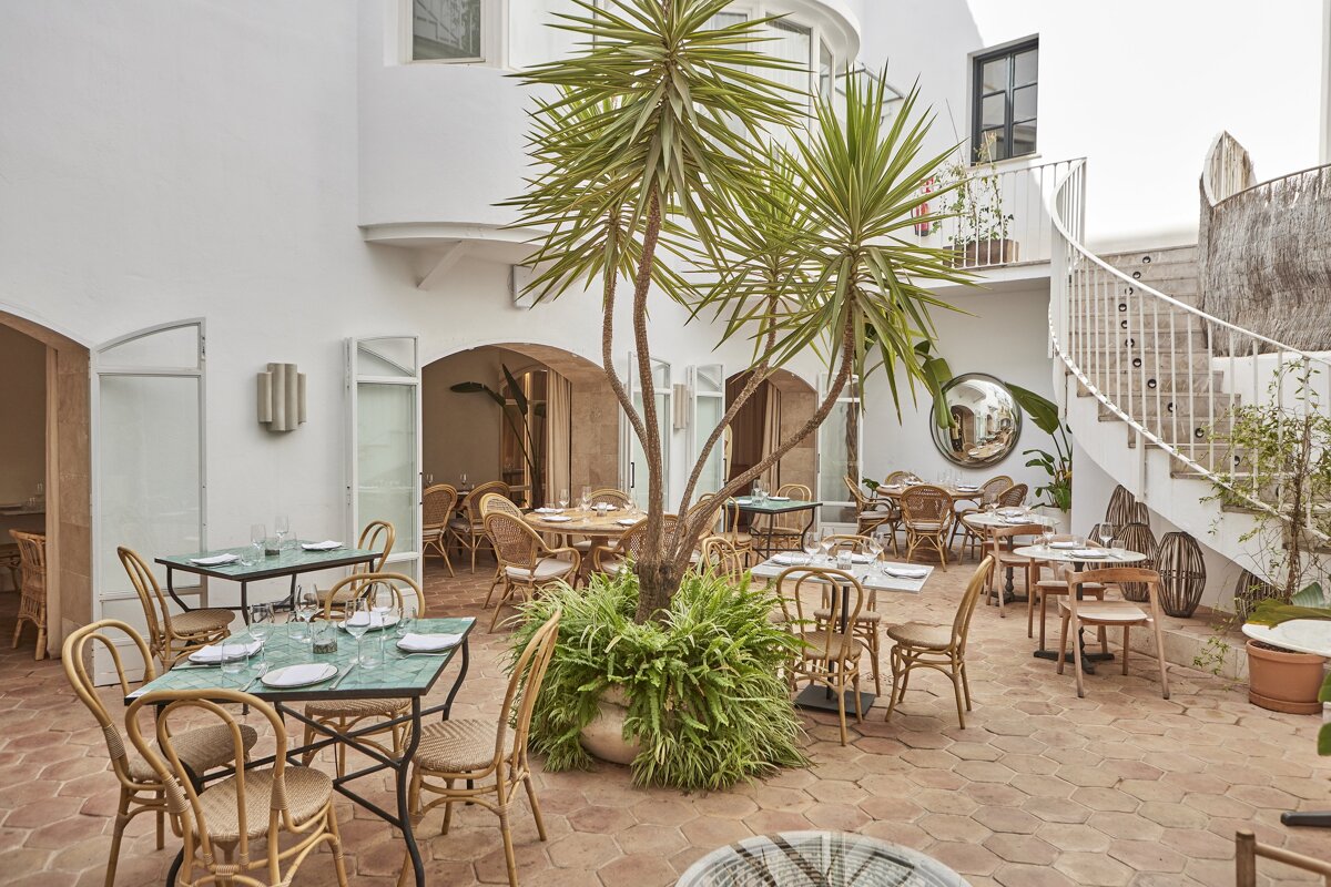 A restaurant with tables and chairs in a courtyard
