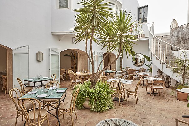 A restaurant with tables and chairs in a courtyard