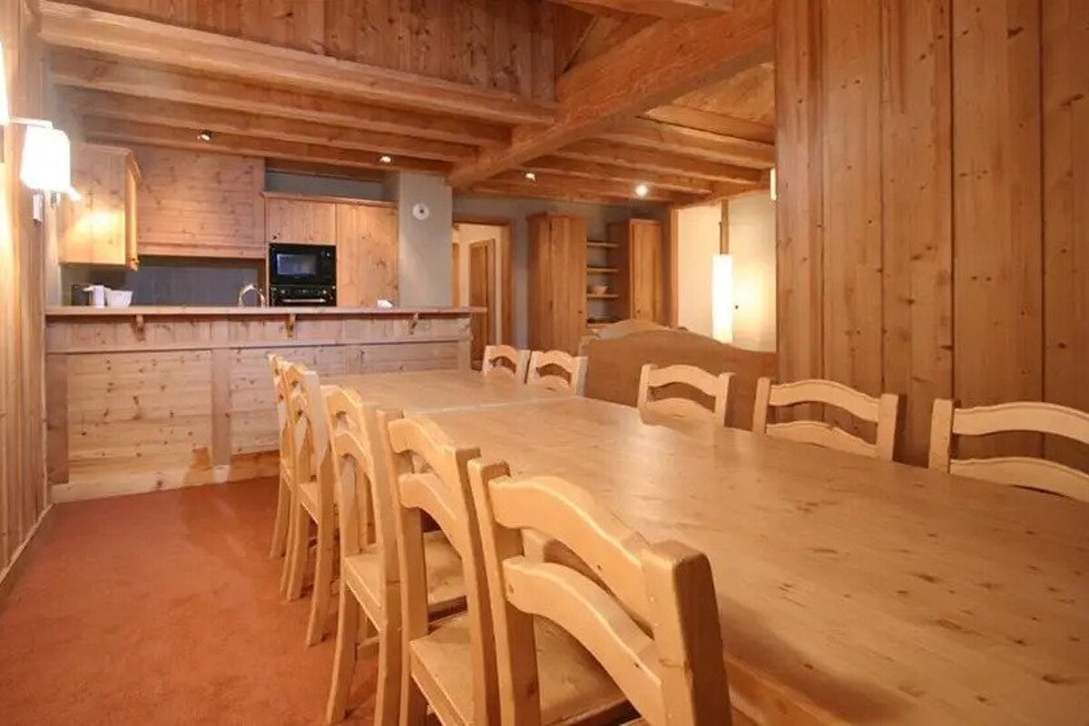 A dining room with a long wooden table and chairs