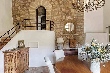A dining room table with a vase of flowers on it
