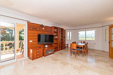 A living room with a table and chairs and a flat screen tv